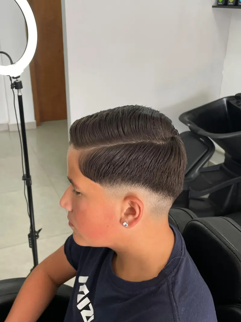 Corte infantil com degradê e risco lateral, penteado para trás